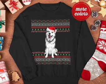 Puede incluir: Sudadera negra con un perro husky blanco que lleva un gorro de Papá Noel rojo. El perro está sentado sobre un patrón navideño rojo y verde con bastones de caramelo y árboles.