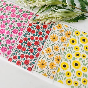 May include: Four different floral patterned cards with white backgrounds. The patterns feature pink flowers, red roses, yellow sunflowers, and a mix of yellow and orange flowers.