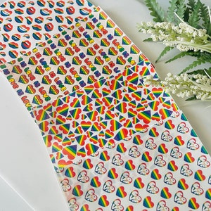 May include: Four sheets of white paper with different rainbow-colored patterns. The patterns include hearts, lips, and the text "Love is Love".