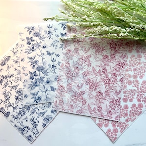 May include: Several sheets of decorative paper with floral and scenic patterns. The papers feature designs in blue and red hues on a white background. The floral patterns include roses, birds, and botanical elements, suitable for crafts and scrapbooking.