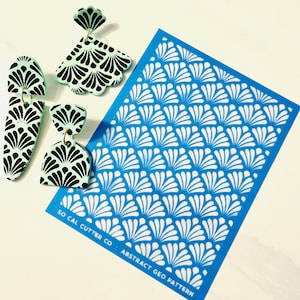 May include: A blue stencil with a white geometric pattern of overlapping fans. The stencil is labeled "SO CAL CUTTER CO. ABSTRACT GEO PATTERN".