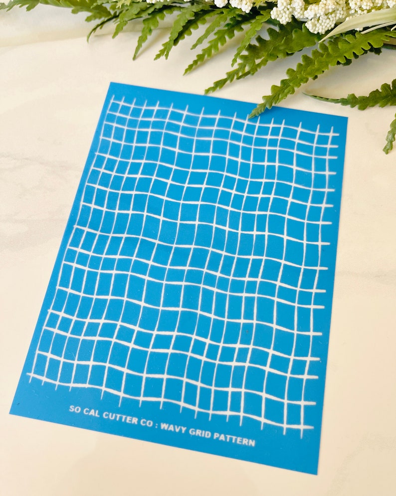 Może przedstawiać: Niebieski szablon z białym falistym wzorem siatki. Szablon zawiera tekst "SO CAL CUTTER CO: WAVY GRID PATTERN" na dole.
