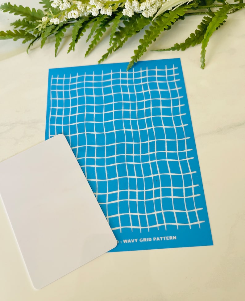Może przedstawiać: Niebieski szablon z białym falistym wzorem siatki. Tekst "WAVY GRID PATTERN" jest nadrukowany na dole szablonu.