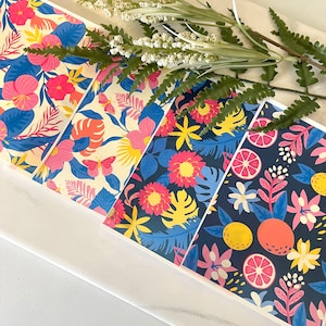 May include: Four different patterned cards with tropical floral and fruit designs. The cards feature bright colors like pink, yellow, blue, and green. The designs include flowers, butterflies, lemons, and oranges.