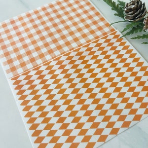 Op de afbeelding: Twee vellen decoratief papier met een bruin en wit geruit patroon. Een vel heeft een gingham-patroon en het andere een ruitpatroon.