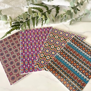 May include: Four patterned sheets of paper with geometric designs in shades of red, orange, yellow, blue, black, and white. The patterns are inspired by traditional tribal art.