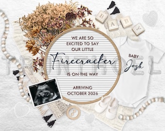 May include: A white letter board with the text "We are so excited to say our little Firecracker is on the way. Arriving October 2026". The letter board is surrounded by dried flowers, a white onesie with the text "Baby Josh", a white knitted blanket, and a white beaded garland.