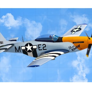 Puede incluir: Un avión azul, blanco y amarillo con una estrella en el lateral y el texto "Miss KANDY" en el fuselaje. El avión está volando en un cielo azul con nubes blancas.