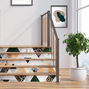 May include: A set of stairs with a geometric pattern of black, white, green, and gold triangles. The stairs are made of wood and have a white railing. A potted plant is in the corner of the room.