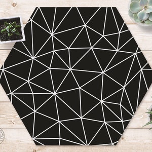 May include: Black hexagonal coaster with a white geometric pattern of triangles.