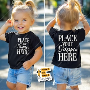May include: A black t-shirt mockup for kids with the text "PLACE YOUR DESIGN HERE" on the front and back. The shirt is being worn by a child with blonde hair and blue jeans. The image includes a logo for "move as bees mockups".