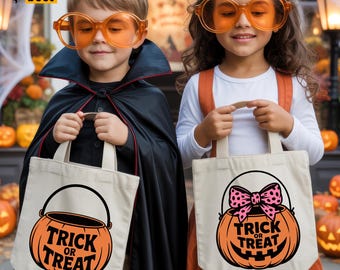 May include: Two children dressed in Halloween costumes, each holding a cream-colored tote bag. The bags feature a jack-o'-lantern design with the words "Trick or Treat." One child wears a black cape, the other an orange dress. Both wear orange-tinted glasses.