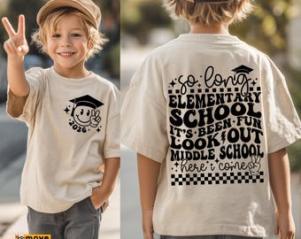 May include: Beige t-shirt with a graduation-themed smiley face graphic and the year 2026. The back of the shirt says "So long Elementary School, It's Been Fun, Look Out Middle School, Here I Come". The child is wearing gray shorts.