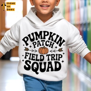 Può includere: Felpa con cappuccio bianca con la scritta "PUMPKIN PATCH FIELD TRIP SQUAD" in nero, con una grafica di zucca arancione. La felpa ha maniche lunghe e un cappuccio con coulisse. L'immagine include anche il testo "move as bees" in giallo.