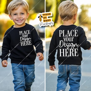 May include: A black sweatshirt mockup for kids with the text "PLACE YOUR DESIGN HERE" on the front and back. The sweatshirt is being worn by a child wearing blue jeans.