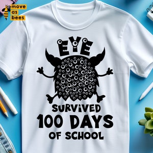May include: White t-shirt featuring a black monster graphic with the word "EYE" above it. The text "SURVIVED 100 DAYS OF SCHOOL" is below the monster. The shirt is on a blue background with pens and a small plant.