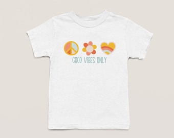 May include: White t-shirt with a peace sign, flower, and heart graphic. The text "Good Vibes Only" is printed below the graphic.