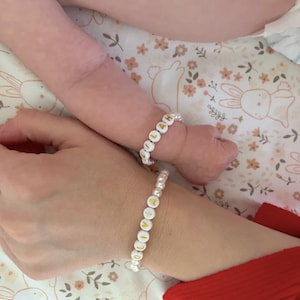 Puede incluir: Dos pulseras de cuentas con cuentas redondas blancas y letras doradas. Una pulsera muestra el nombre OLIVIA y la otra el nombre LILLAH. Las pulseras est&aacute;n hechas con peque&ntilde;as perlas blancas intercaladas entre las cuentas de letras.