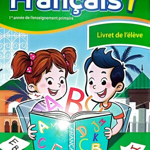 Könnte beinhalten: Ein Schulbuchcover mit dem Titel "Français 1" für das erste Schuljahr. Das Cover zeigt zwei Kinder, die ein Buch mit dem Alphabet lesen. Das Buch trägt die Aufschrift "Livret de l'élève" und die Ausgabe ist von 2025.