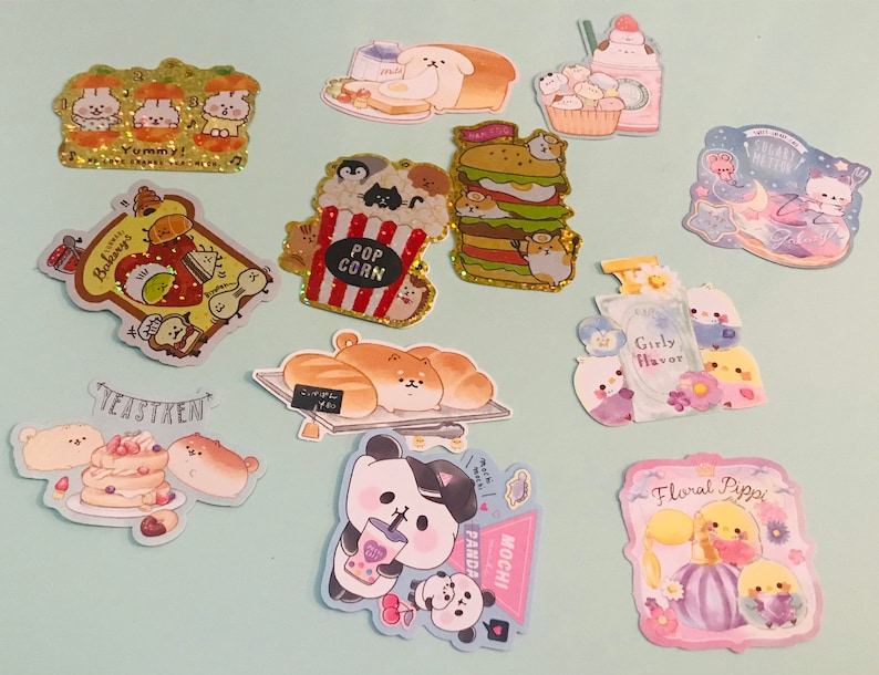 May include: A collection of colorful stickers featuring cute animal characters and various themes, including bakery, popcorn, panda, and floral. The stickers are perfect for adding a touch of whimsy to journals, planners, and other creative projects.
