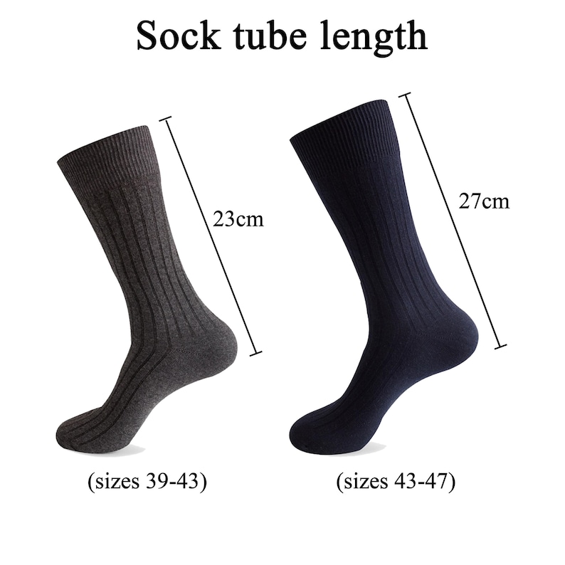 K&ouml;nnte beinhalten: Zwei gerippte Socken, eine anthrazitfarbene und eine marineblaue, mit dem Text Sock tube length. Die graue Socke misst 23 cm f&uuml;r die Gr&ouml;&szlig;en 39-43, die marineblaue Socke misst 27 cm f&uuml;r die Gr&ouml;&szlig;en 43-47, dargestellt mit Messlinien.