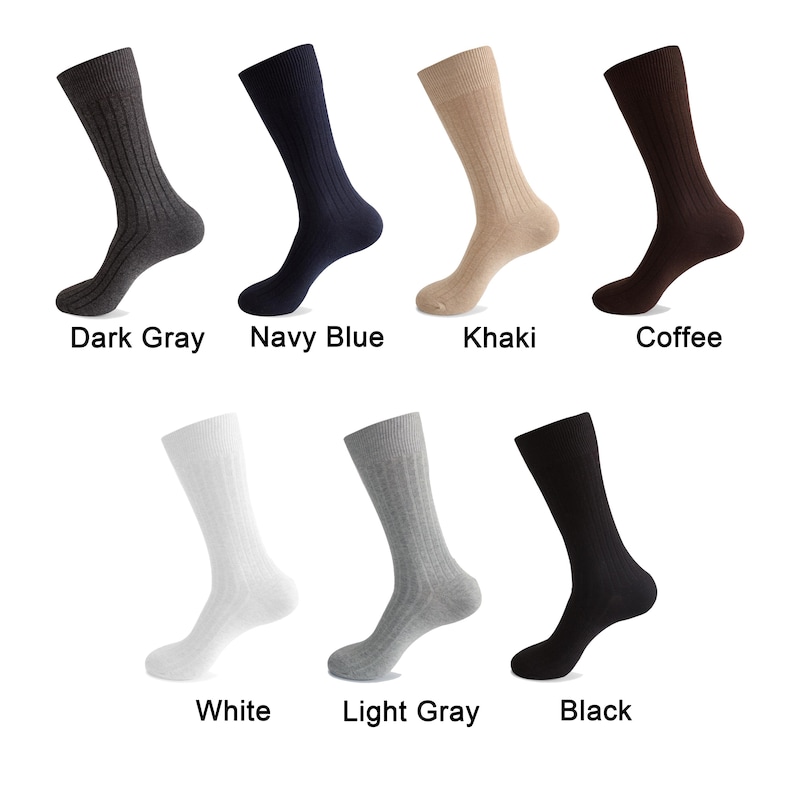 K&ouml;nnte beinhalten: Eine Kollektion von sieben gerippten Socken in verschiedenen Farben, darunter Dunkelgrau, Marineblau, Khaki, Kaffee, Wei&szlig;, Hellgrau und Schwarz. Jede Socke weist eine vertikale Rippenstruktur und eine klassische mittlere Schaftl&auml;nge auf.
