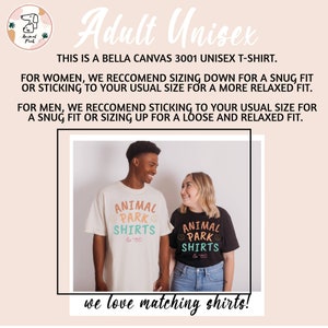 May include: Two people wearing matching t-shirts with the text "Animal Park Shirts" in a colorful design. The shirts are white and black. The people are smiling and looking at each other.