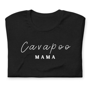 Op de afbeelding: Zwart T-shirt met witte tekst die "Cavapoo Mama" zegt.