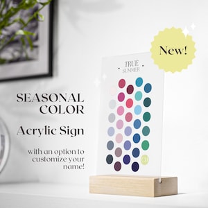 Puede incluir: Letrero acrílico con una paleta de colores para "True Summer" con una base de madera. El letrero muestra una gama de colores, incluyendo rosas, azules y verdes. El texto en el letrero dice "SEASONAL COLOR Acrylic Sign" y "with an option to customize your name!"