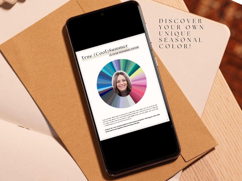 May include: A smartphone displaying a color wheel with a woman's face in the center. The text on the screen reads "True (Cool) Summer If Your Personal Color". The text above the phone reads "DISCOVER YOUR OWN UNIQUE SEASONAL COLOR!"
