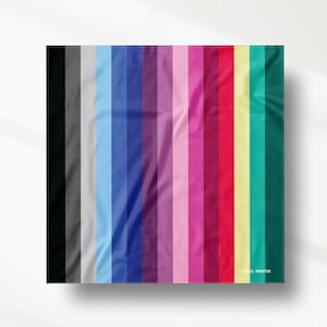 Op de afbeelding: Een vierkant stoffen staal met een verticaal streeppatroon in een kleurverloop van zwart, grijs, lichtblauw, koningsblauw, paars, roze, magenta, rood, geel, taling en donkergroen, met de tekst COOL WINTER in het wit afgedrukt.