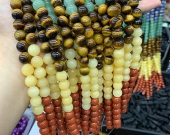 May include: A strand of beads with alternating colors of green, brown, yellow, and red. The beads are round and smooth.