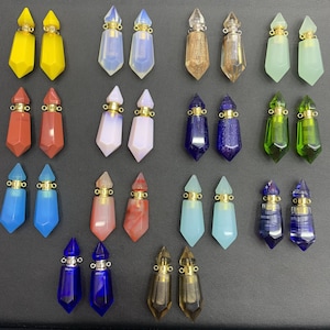 May include: Assortment of 20 crystal glass bottle stoppers in various colours and shapes. The stoppers have a gold metal top with a loop for hanging.
