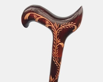 May include: A wooden walking stick with a carved floral design. The stick is dark brown with light brown floral carvings.