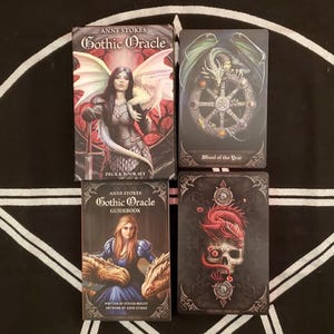 Pode incluir: Quatro itens do Oráculo Gótico são exibidos em uma superfície com padrões em preto e branco. Os itens incluem um baralho e um conjunto de livros, um guia e dois cartões. O baralho e o conjunto de livros apresentam uma mulher com asas.