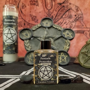 Pode incluir: Uma coleção de itens espirituais, incluindo uma garrafa de Óleo Espiritual Pentacle Protection, uma vela e um pentáculo decorativo. A garrafa de óleo e a vela apresentam um símbolo de pentáculo. O fundo inclui uma tapeçaria decorativa e pedras pretas.