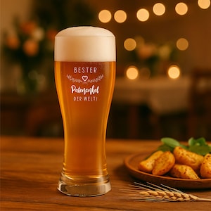 May include: A tall beer glass filled with golden beer and a thick white head. The glass has the words "BESTER Patenonkel DER WELTI" in white script. A wooden plate with potato wedges and a sprig of wheat are in the background.