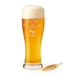 May include: A tall beer glass filled with golden beer and a foamy head. The glass has the words "BESTER Papa DER WELTI" in white script with a heart and floral design. A single wheat stalk rests beside the glass.