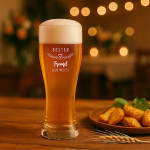 May include: A tall beer glass filled with golden beer and a thick white head. The glass has the words "BESTER Freund DER WELT!" etched on it. A wooden plate with potato wedges and a sprig of wheat are on the table.