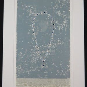 May include: A blue and white necklace hangs against a light blue background with white speckles. The necklace is in the shape of a teardrop.