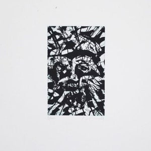May include: Black and white abstract print of a face with a textured background.