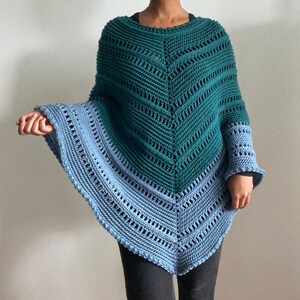 May include: A teal and blue knitted poncho with a V-shaped neckline and a crocheted design.