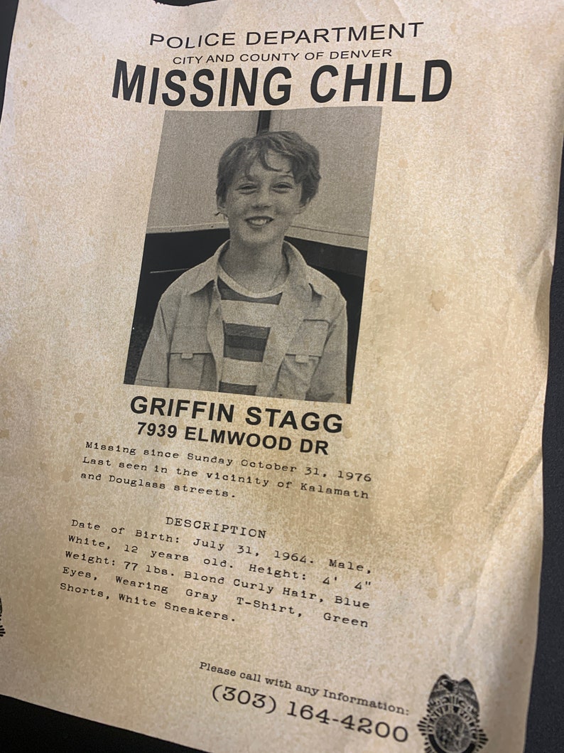 May include: A missing child poster with a photo of a young boy with blond hair. The poster includes the boy's name, Griffin Stagg, his address, 7939 Elmwood Dr, and a description of his appearance. The poster also includes a phone number to call with any information: (303) 164-4200.