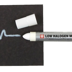May include: White low halogen marker pen with a silver cap and label that reads "LOW HALOGEN MARKER" and "Less Halogens (Br, Cl, F) and Metal ingredients (Sn, Hg, Cd, Pb, Fe, Ni, Cr, Cu, Co, Ti)". The marker is on a black surface with a white line drawn on it.