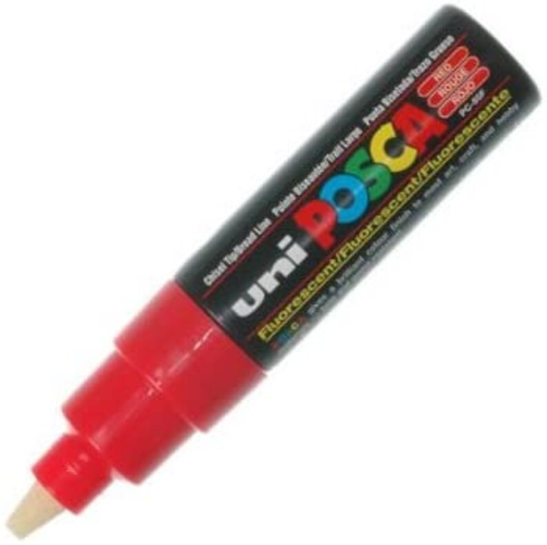 May include: A red Uni Posca paint marker with a chisel tip. The marker is labeled "Fluorescent/Fluorescent/Fluorescente" and "PC-S".