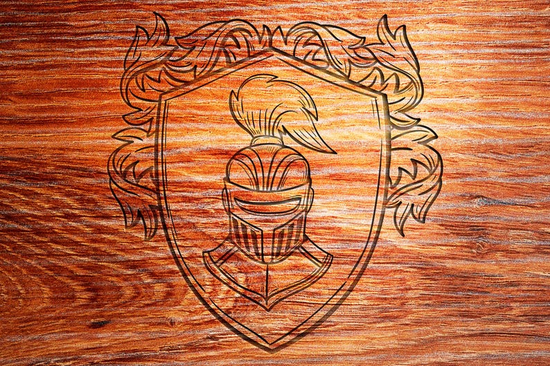 May include: A black and white line drawing of a knight's helmet with a plume, inside a shield with a decorative border. The image is carved into a wooden surface.