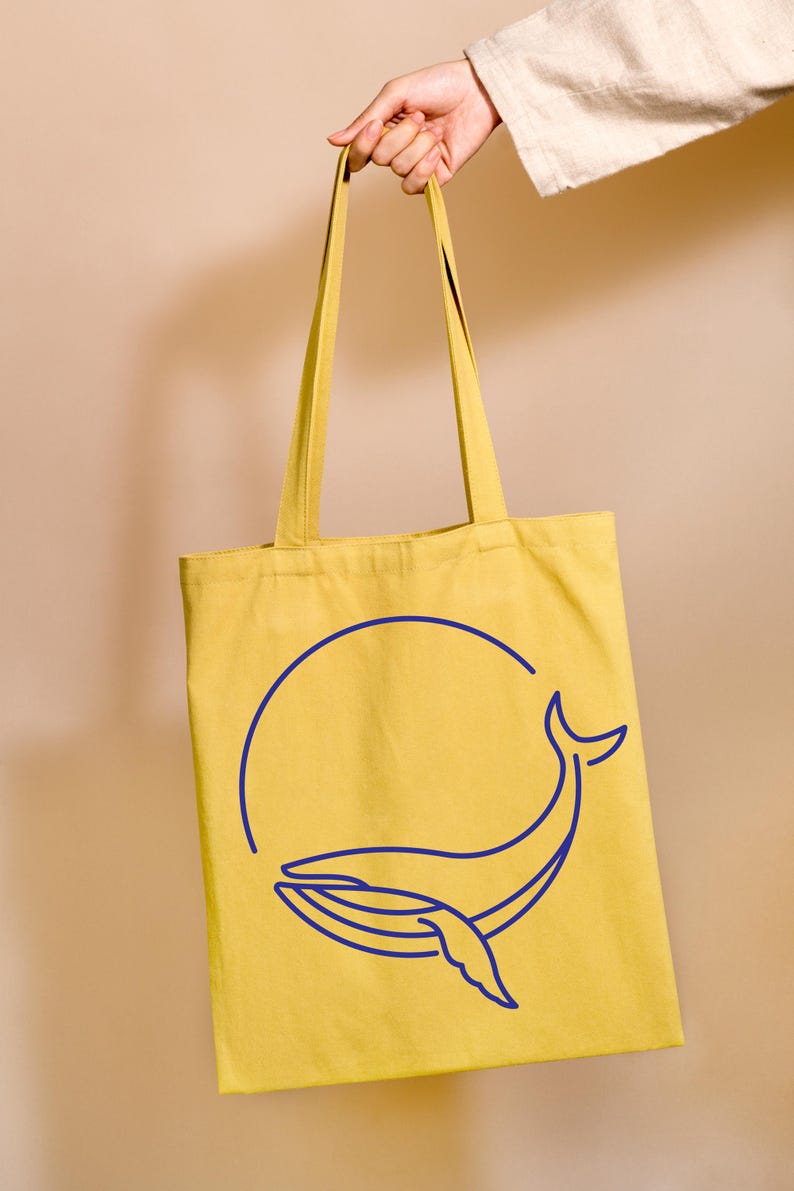 May include: A yellow tote bag with a blue whale outline design. The whale is inside a circle.