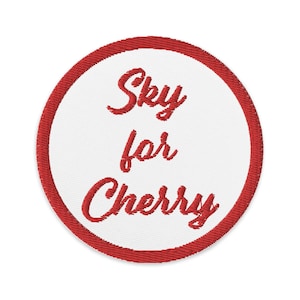 Puede incluir: Parche bordado rojo con fondo blanco y el texto "Sky for Cherry" en una fuente cursiva.