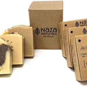 May include: Three bars of handmade soap in a brown cardboard box. The soap is a light brown colour with a brown and white swirl design. The box is labelled "Naza Naturals" and "All Natural Handcrafted Soap" with the scent "Yang-Yang Bergamot".