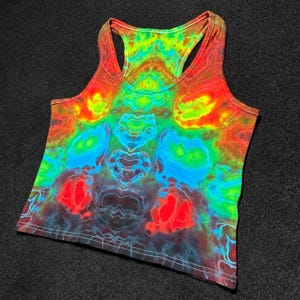 May include: A vibrant tie-dye tank top in a racerback style. The top features a kaleidoscope of colors, including red, orange, yellow, green, and blue, creating a psychedelic pattern. The fabric appears soft and lightweight, suitable for warm weather.